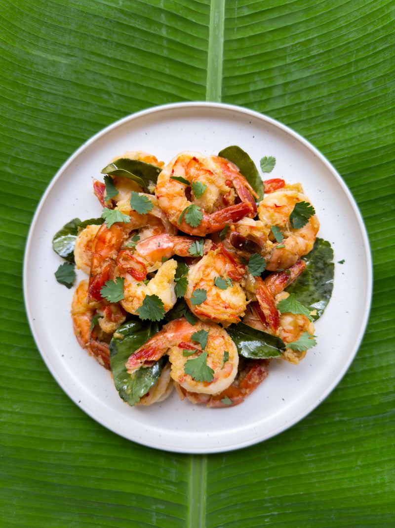 Prawns with coriander and chilli, served on a plate over a banana leaf