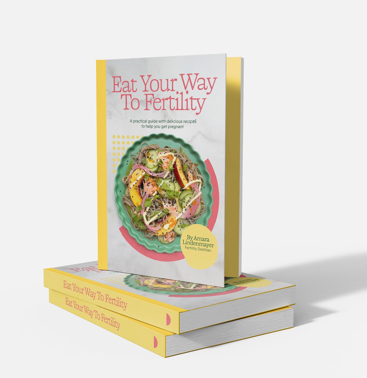 Eat Your Way To Fertility cookbook standing upright on a stack of copies
